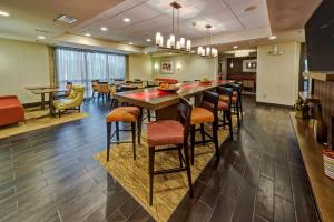 a restaurant with a bar with chairs and tables at Hampton Inn Houston Baytown in Baytown