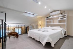 una camera con un grande letto bianco e un balcone di Hauzify I Casa Palou a Palamós