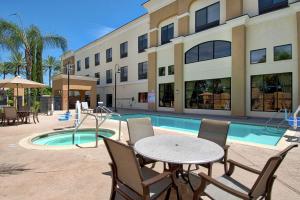 un patio con mesa y sillas junto a una piscina en Hampton Inn & Suites by Hilton Hemet Menifee Murrieta, en Hemet