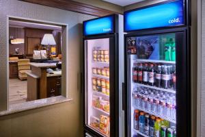 a refrigerator filled with lots of bottles of soda at Hampton Inn & Suites Houston Rosenberg in Rosenberg