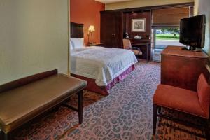 a hotel room with a bed and a chair at Hampton Inn Ashland in Ashland