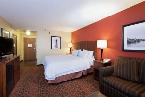 a hotel room with a bed and a couch at Hampton Inn Houma in Houma