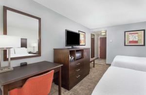 a hotel room with a desk and a bed and a television at Hampton Inn Cullman in Cullman