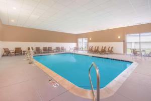 una piscina en una habitación de hotel con sillas y mesas en Hampton Inn Terre Haute, en Terre Haute