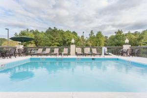 a large swimming pool with chairs and an umbrella at Hampton Inn Havelock in Havelock