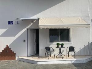 a patio with two chairs and a table and a window at SK Apartment in Neoi Epivates