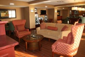 sala de estar con sofá, sillas y mesa en Hampton Inn Hays-North of I-70 en Hays