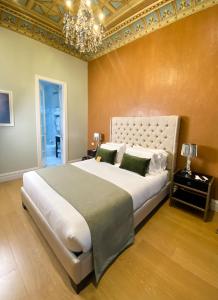 Un dormitorio con una cama grande y una lámpara de araña. en Itza Hotel Boutique Internacional, en Cuenca