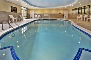 a pool in a hotel with chairs and tables at Hampton Inn Niagara Falls/ Blvd in Niagara Falls