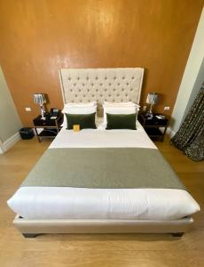 a bedroom with a large white bed with two pillows at Itza Hotel Boutique Internacional in Cuenca