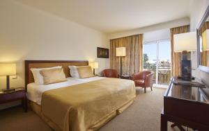 a hotel room with a bed and a balcony at PortoBay Falesia in Albufeira