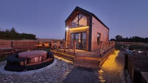 a tiny house with a large deck and a table at Your Holidays Freedom in Zastań