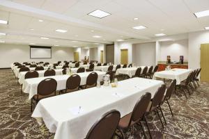 a conference room with white tables and chairs and a screen at Hampton Inn Idaho Falls in Idaho Falls