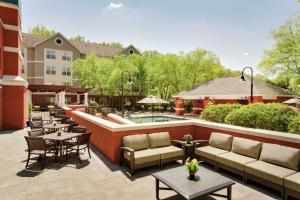 a patio with tables and chairs and a swimming pool at Homewood Suites by Hilton Wilmington-Brandywine Valley in Talleyville