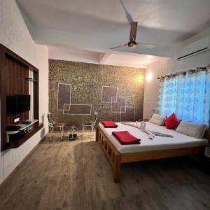 a bedroom with a large bed with red towels on it at Mybhumi Resort in Malshej Ghat