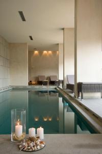 una piscina con candele e un tavolo con un piatto con candele di Egnatia City Hotel & Spa a Kavala