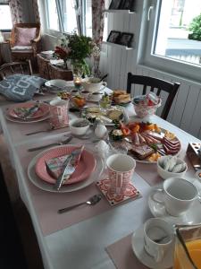 a table with plates and bowls of food on it at Saarlouis, Ortsteil Beaumarais "Anna's Cottage"Bed&Breakfast "#TravellerAwards 2022" in Saarlouis