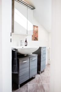 a bathroom with a sink and a mirror at Ferienwohnung - Haus am Sonnenhang in Wertach