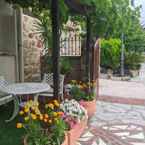 un patio con mesa, sillas y flores en Casa Rural Bilbao Caserio Gondra Alquiler Habitaciones en Mungia