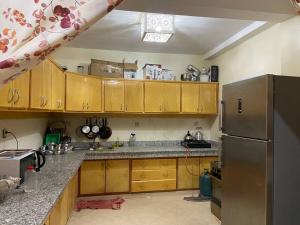 een keuken met houten kasten en een roestvrijstalen koelkast bij 4 Seasons Guesthouse Gafait 