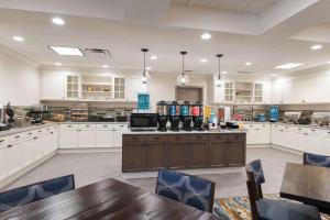 a large kitchen with white cabinets and a table and chairs at Homewood Suites by Hilton Indianapolis Northwest in Indianapolis