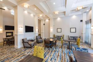 a lobby with tables and chairs and a flat screen tv at Homewood Suites by Hilton Indianapolis Northwest in Indianapolis
