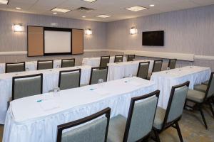 a conference room with tables and chairs and a screen at Homewood Suites by Hilton Indianapolis Northwest in Indianapolis