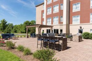 a patio with a table and chairs in front of a building at Homewood Suites by Hilton Indianapolis Northwest in Indianapolis