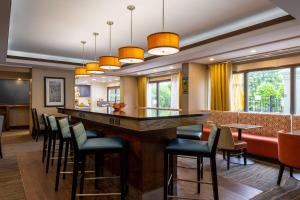 a bar in a restaurant with stools at Hampton Inn Winston-Salem Hanes Mall in Winston-Salem