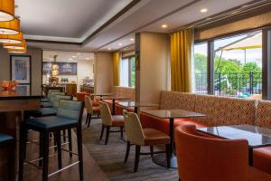 um restaurante com mesas, cadeiras e janelas em Hampton Inn Winston-Salem Hanes Mall em Winston-Salem