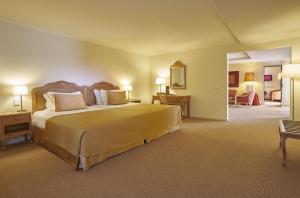 a hotel room with a large bed and a living room at PortoBay Falesia in Albufeira
