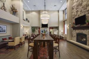 a lobby with a fireplace and a table and chairs at Hampton Inn & Suites Williston in Williston