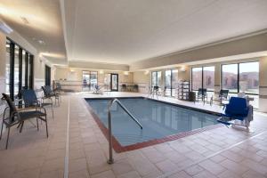 a pool in a hotel with chairs at Hampton Inn & Suites Williston in Williston