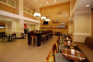 a restaurant with tables and chairs and a dining room at Hampton Inn Jackson/Flowood - Airport Area MS in Luckney