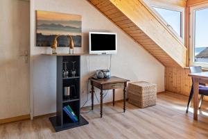 a living room with a desk and a tv at Haus Unterseeblick Sonnenuntergang in Gaienhofen