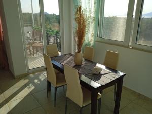 a dining room table with chairs and a vase on it at Denise Villa in Platánion