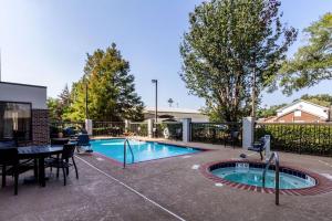a swimming pool with a table and chairs and a table and a tablektopktop at Hampton Inn Jackson Pearl Intrntl Airport in Pearl