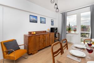 a dining room with a table and chairs and a window at Apartment Podwale Staromiejskie Gdańsk with Balcony by Renters in Gdańsk