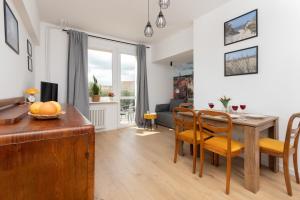 a dining room and living room with a table and chairs at Apartment Podwale Staromiejskie Gdańsk with Balcony by Renters in Gdańsk