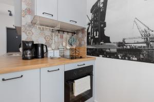 a kitchen with white cabinets and a black oven at Apartment Podwale Staromiejskie Gdańsk with Balcony by Renters in Gdańsk