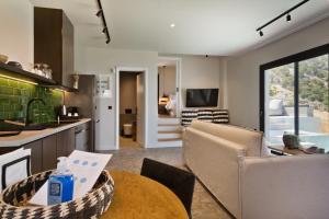 a kitchen and living room with a table and a couch at Aposperia Memorable Living in Kyra Panagia