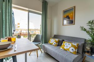 a living room with a couch and a table at Piton des Neiges - Nid douillet terrasse vue port in Arcachon