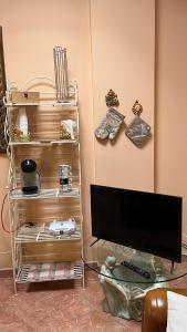 a flat screen tv sitting on a glass table next to a wall at Casa Giusy in San Marzano di San Giuseppe