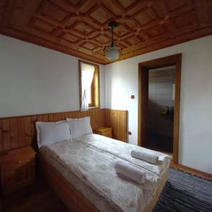 a bedroom with a bed with two pillows on it at Villa Lyutovi Holiday Home in Koprivshtitsa