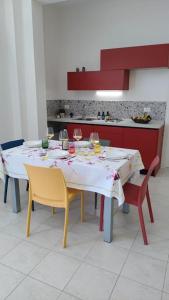 une table à manger avec des chaises et un tissu de table blanc dans l'établissement Colori del Belice appartamento, à Santa Ninfa