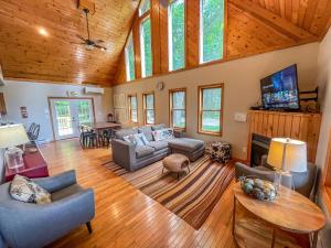 a living room with a couch and a tv at Modern Cabin with Hot Tub and Fire Pit in Swanton