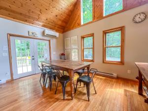 a dining room with a wooden table and chairs at Modern Cabin with Hot Tub and Fire Pit in Swanton