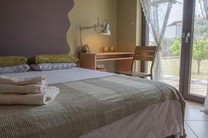 - une chambre avec un lit, un bureau et une fenêtre dans l'établissement Leveniotis Villa, à Angelochórion