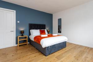 ein Schlafzimmer mit einem Bett und einer blauen Wand in der Unterkunft Plessey House Blyth by #ShortStaysAway in Cowpen
