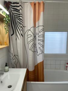 a bathroom with a shower curtain with a plant on it at Chambre double cassis in Cassis